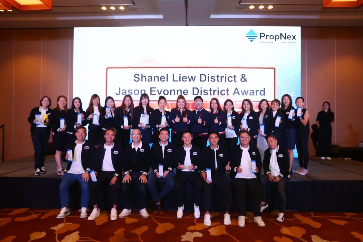 A full PropNex district group photo at an awards ceremony.